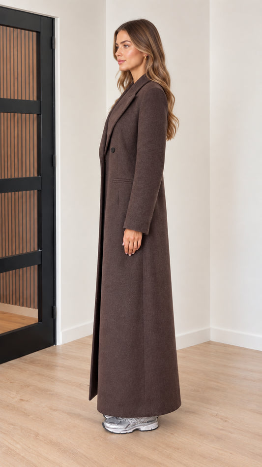 Side profile view of woman wearing long chocolate brown overcoat