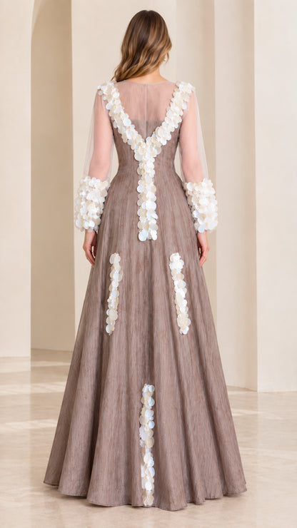 Back full-length view of taupe formal gown featuring sheer back yoke and vertical petal trims