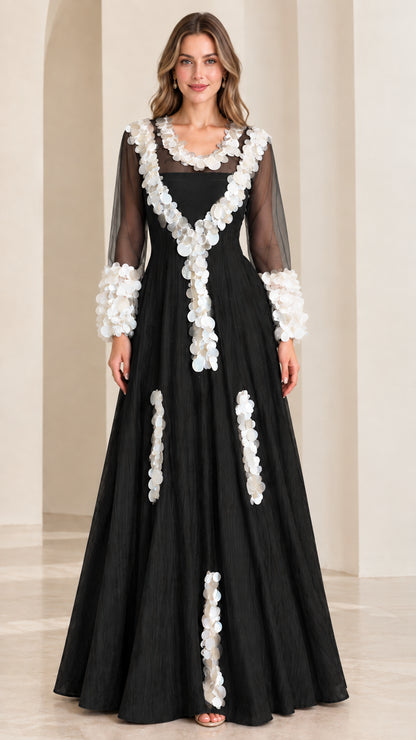 Front full-length view of black A-line evening maxi gown with contrasting white petal embellishments